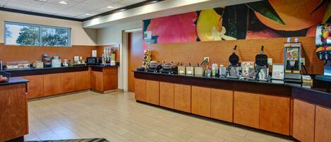 A modern kitchen with wooden cabinets, a central island, and a colorful abstract mural on the wall.