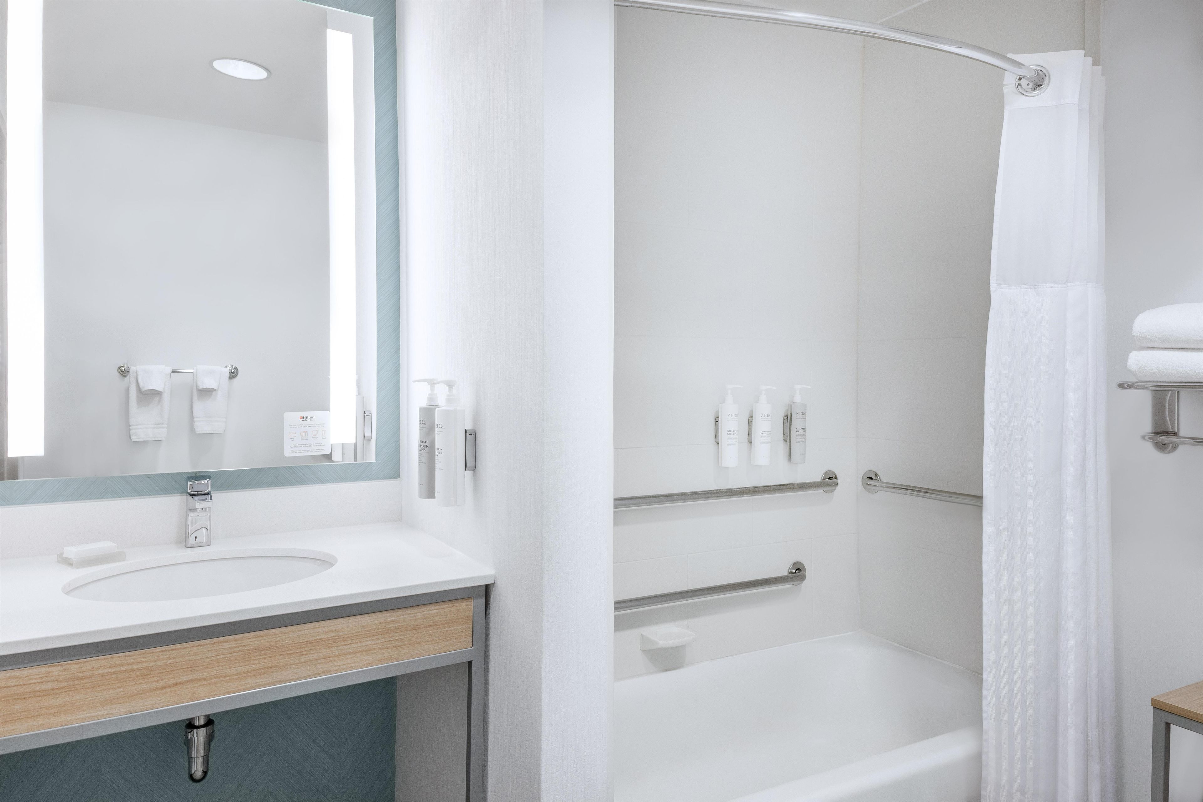 Ein modernes Badezimmer mit Waschbecken, Spiegel und Dusche.