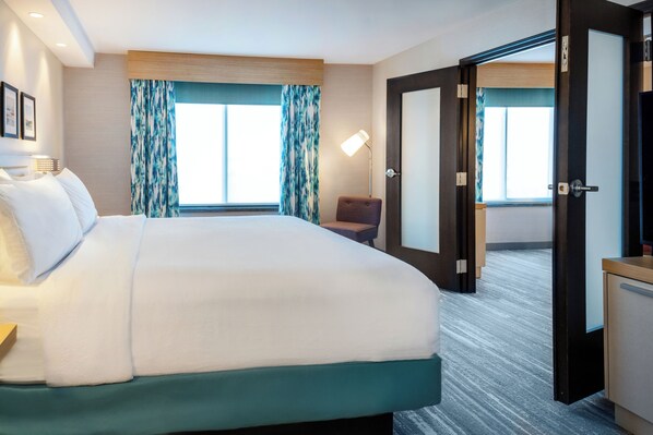 A hotel room with a large bed, a desk, a chair, and a television. - Hilton Garden Inn Sioux Falls South (Sioux Falls)