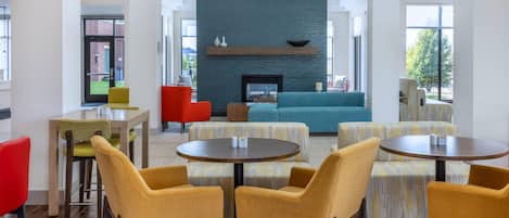 Ein stilvoller Lounge-Bereich mit Kamin, bequemen Sitzgelegenheiten und Blick ins Freie.