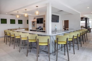 A modern kitchen with a central island, bar stools, and pendant lighting. - Hilton Garden Inn Sioux Falls South (Sioux Falls)