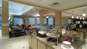 A hotel breakfast area with buffet counters, seating arrangements, and a skylight. - Hilton Garden Inn Mount Holly/Westampton (Mount Holly)