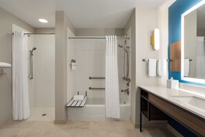 A modern bathroom with a shower, a bathtub, a vanity with a mirror, and a toilet. - Hilton Garden Inn Fort Myers Airport/FGCU (Fort Myers)