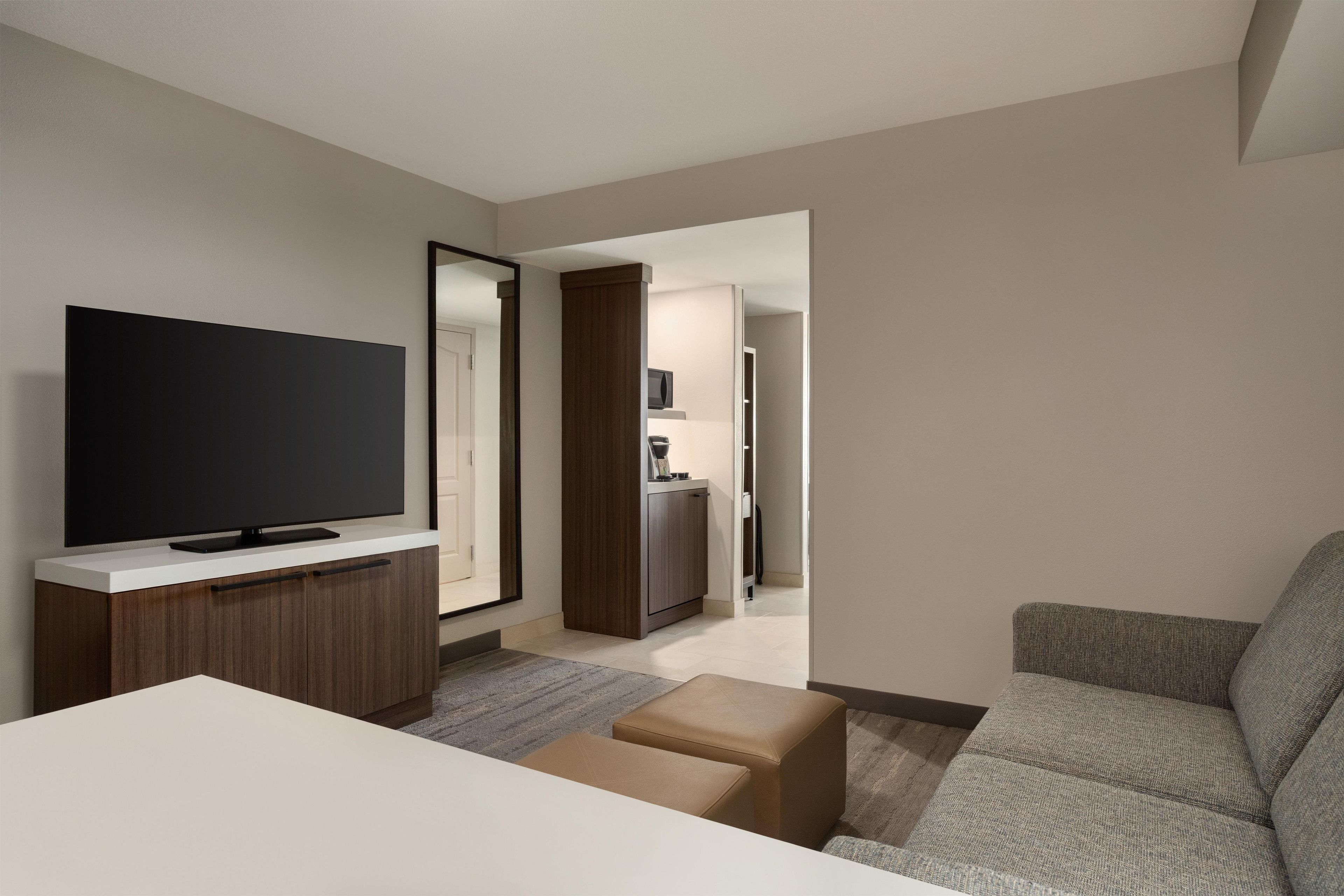 A modern living room with a flat-screen TV, a sofa, and a coffee table.