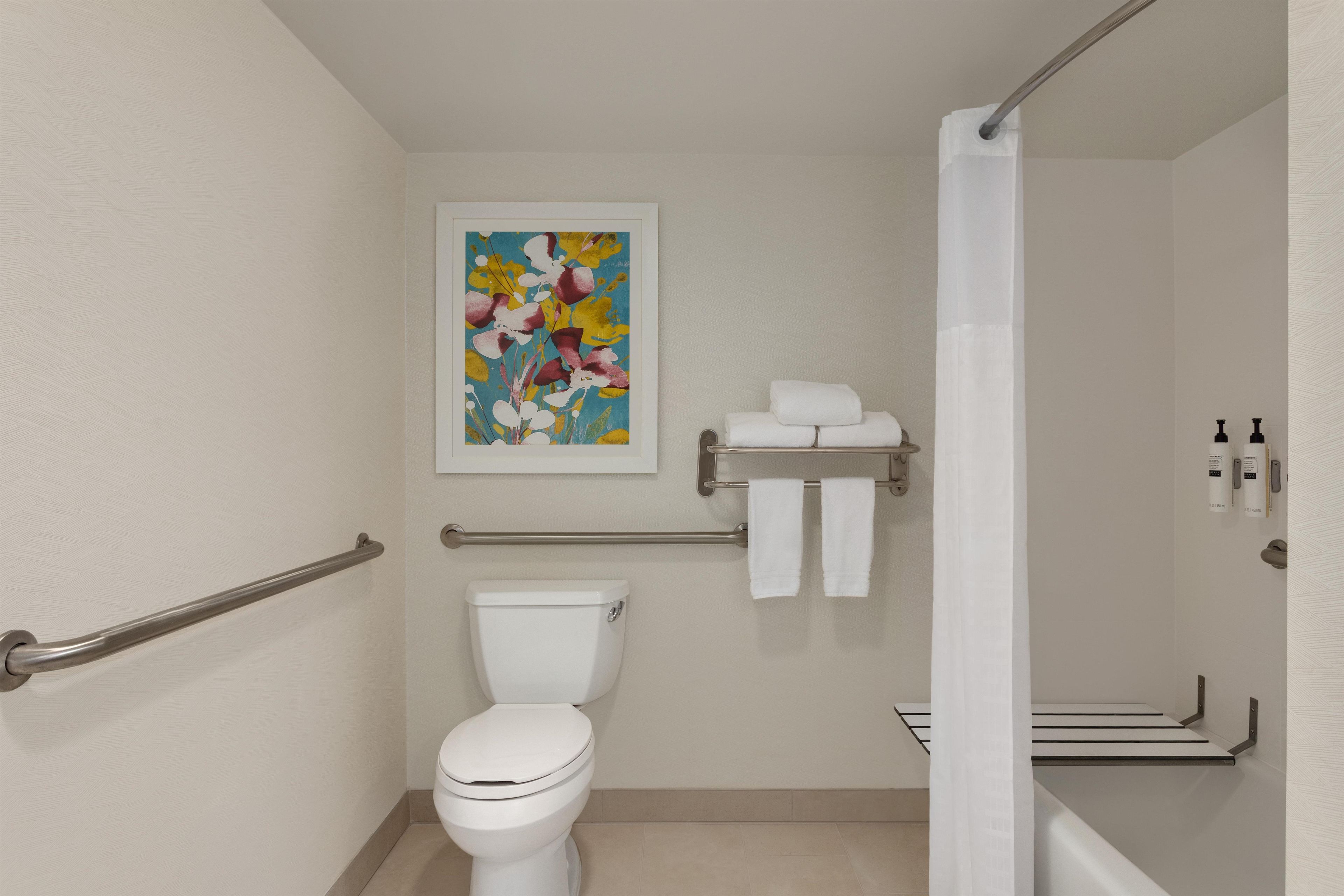 Un baño moderno con inodoro, ducha y toallero.