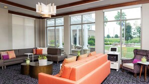 A spacious lobby with a large seating area, a coffee table, and a printer.
