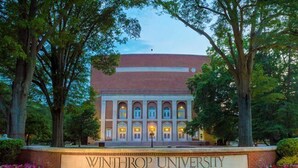 Edificio de la Universidad Winthrop con fachada de ladrillo, ventanas arqueadas y un letrero en la parte frontal.