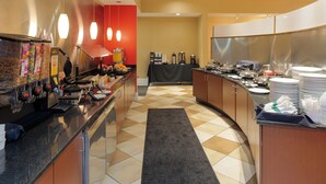 A hotel kitchen with a coffee station, a buffet table, and a seating area. - Holiday Inn Rock Hill by IHG (Rock Hill)
