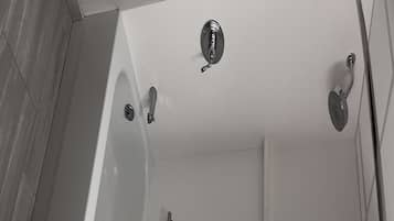 A modern bathroom with a bathtub, a shower, and a toilet.