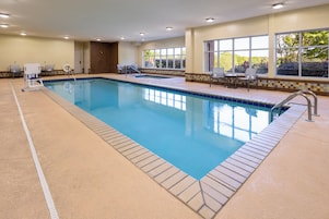 An indoor swimming pool with clear water, tiled edges, and a tiled floor.