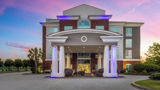 A modern hotel with a symmetrical facade, large entrance, and a central circular logo.