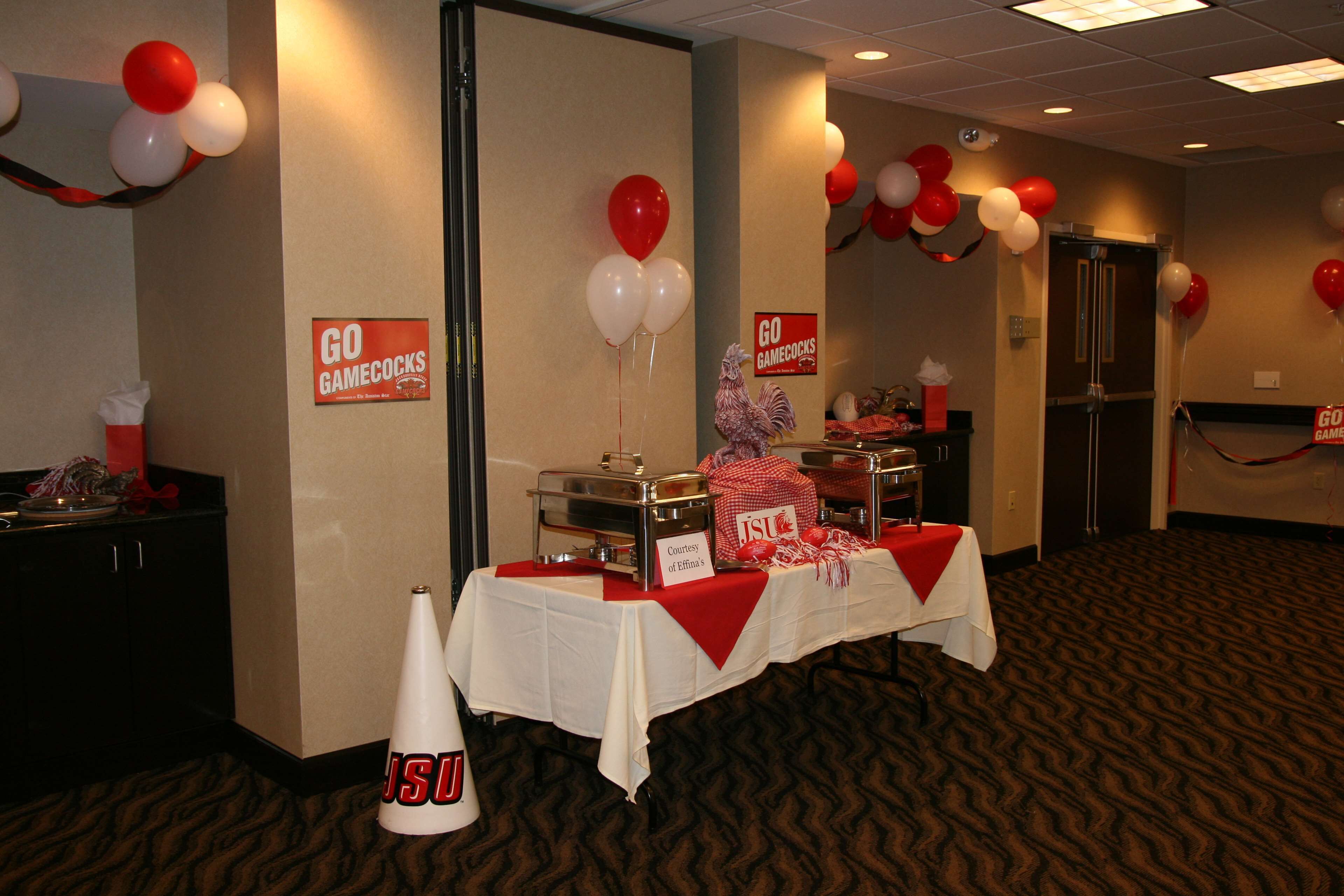 Un salón de conferencias con una mesa de bufé, globos y carteles que dicen 'GO GAMECOCKS'.