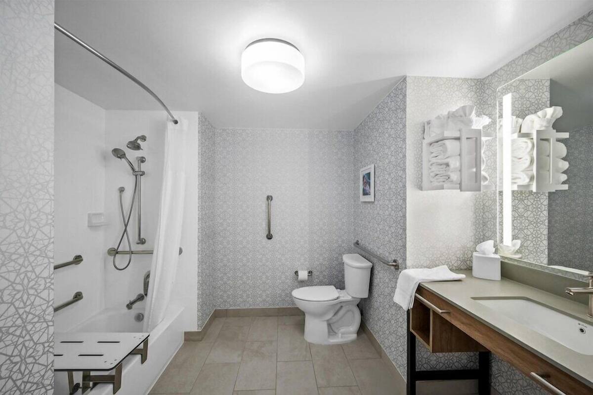 Un baño moderno con ducha, inodoro y tocador.