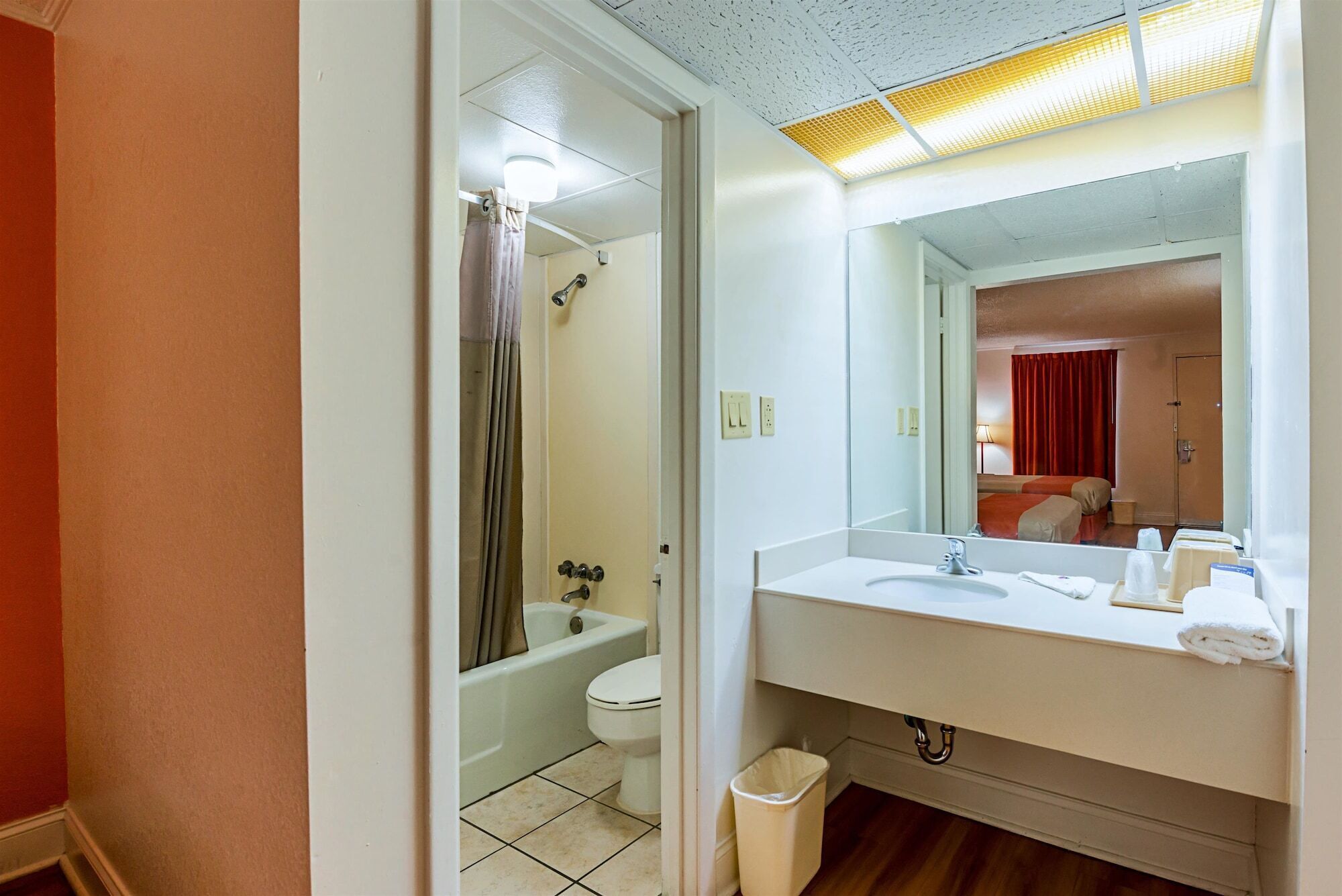 A bathroom with a white sink, mirror, and toilet.