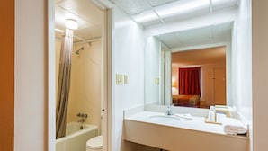 Un baño con bañera, inodoro, lavabo y espejo.