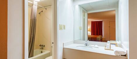 Une salle de bain équipée d’une baignoire, de toilettes, d’un lavabo et d’un miroir.