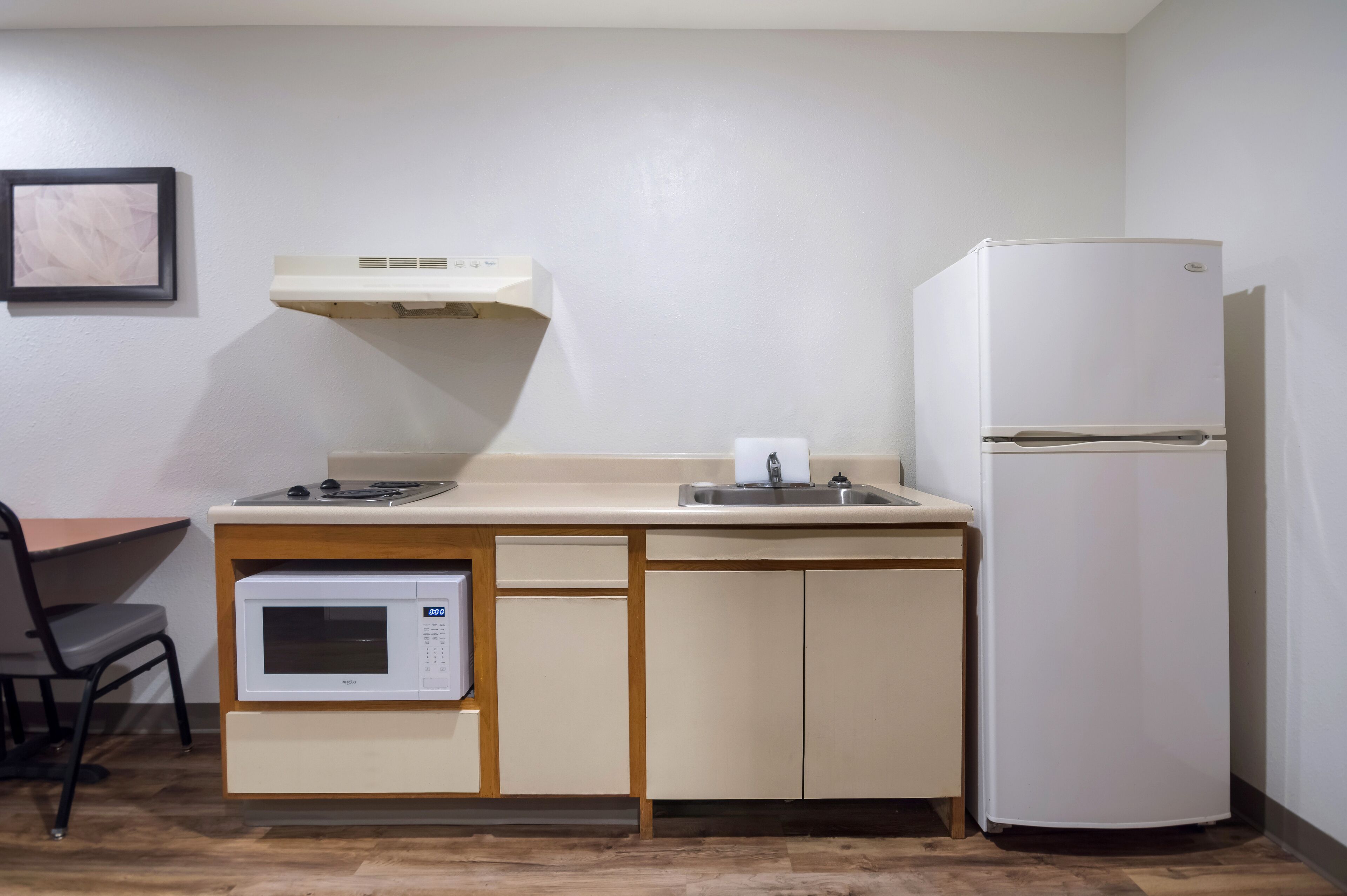 A compact kitchenette with a microwave, sink, and refrigerator.