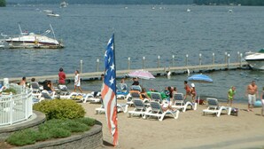 Une plage avec des chaises longues et un drapeau américain.