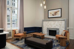 A modern living room with a fireplace, a sectional sofa, a coffee table, and a side table.