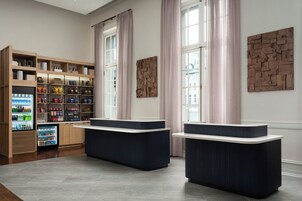 Un área de recepción con mostrador, estantes con aperitivos y un refrigerador.