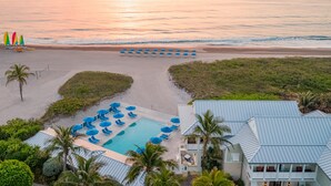 A resort with a pool, beach umbrellas, and a view of the ocean at sunset. - The Seagate Hotel, Golf & Beach Club, Autograph Collection (Delray Beach)