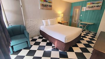 Ein Zimmer mit Bett, Stuhl, Tisch und Tür.
