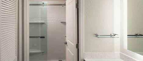 A bathroom with a toilet, a shower, and a sink.