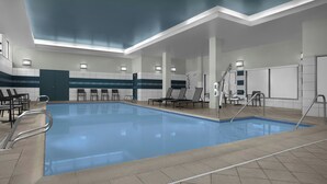 Une piscine dotée d’une terrasse carrelée, de chaises longues et d’un plafond équipé d’un système d’éclairage encastré.