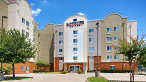 Een hotel met een opvallend 'Candlewood Suites' bord, meerdere verdiepingen en een parkeerplaats.