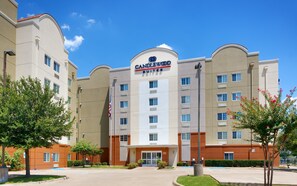 Een hotel met een opvallend 'Candlewood Suites' bord, meerdere verdiepingen en een parkeerplaats.