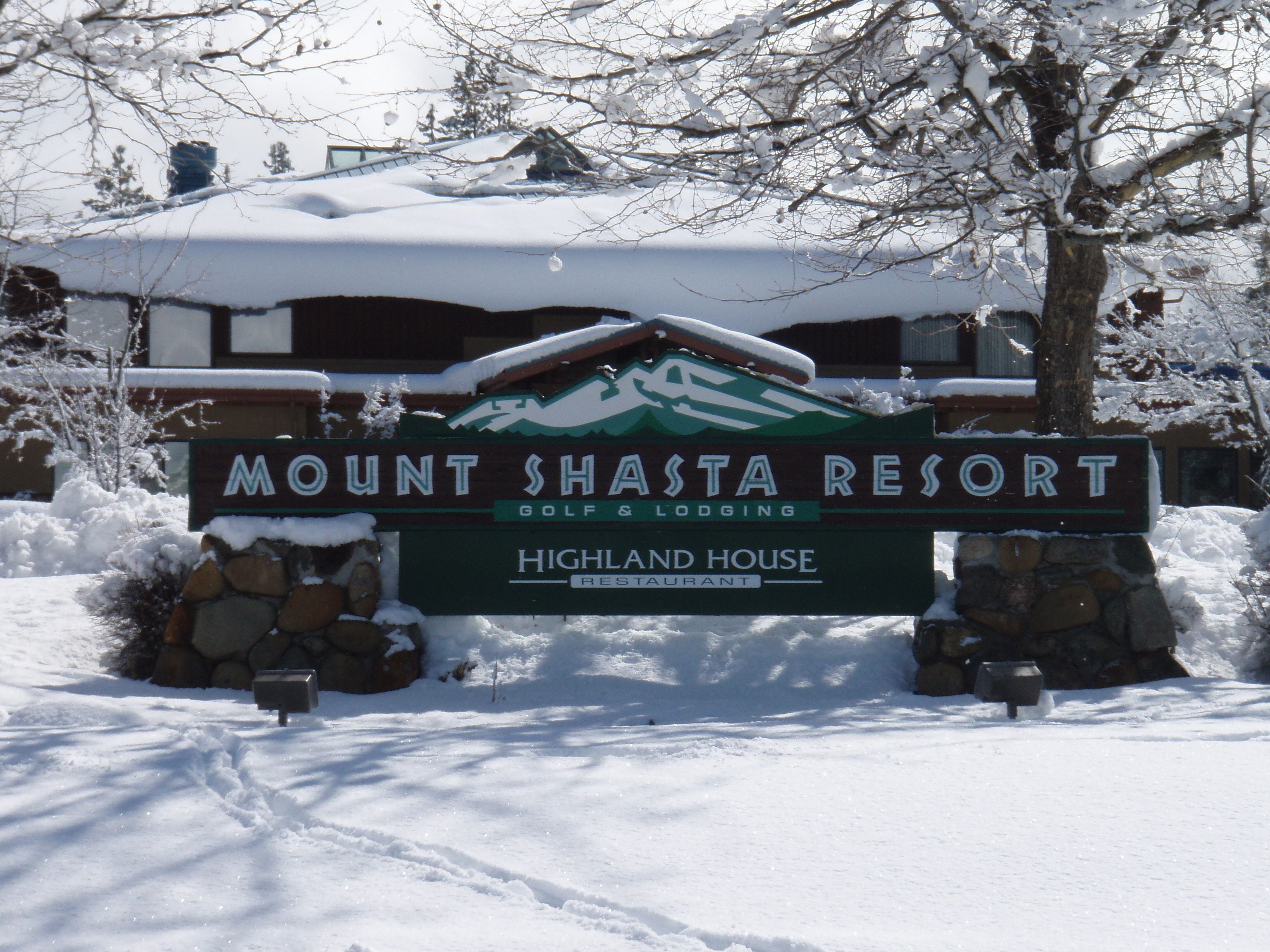 A sign for Mount Shasta Resort with a mountain logo, indicating a golf and lodging facility.