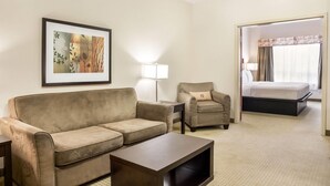 Una habitación de hotel con sofá, sillón y cama.