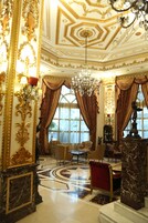 Ein luxuriöser Raum mit aufwendigen Goldverzierungen, einem Chandelier und einem Marmorboden.