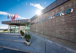 Stunning ABAD SAN ANTONIO building with a modern design, glass entrance, and metal roof.
