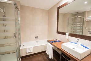 Bathroom features a bathtub, sink, and glass shower enclosure.