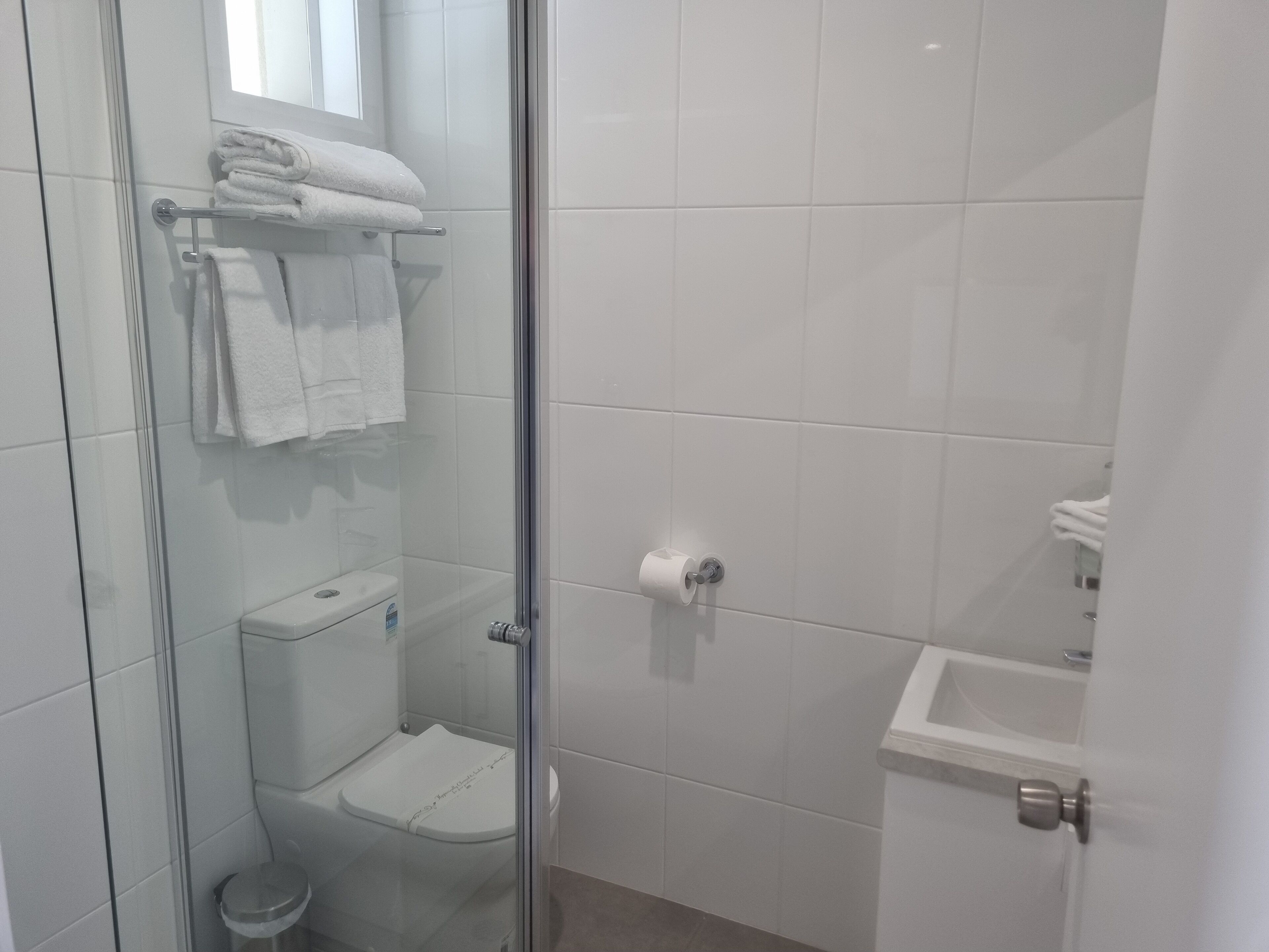 Une salle de bain moderne avec une douche à parois de verre, des toilettes et un lavabo.