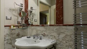 Un bagno con un lavabo in marmo, uno specchio grande e un porta asciugamani.