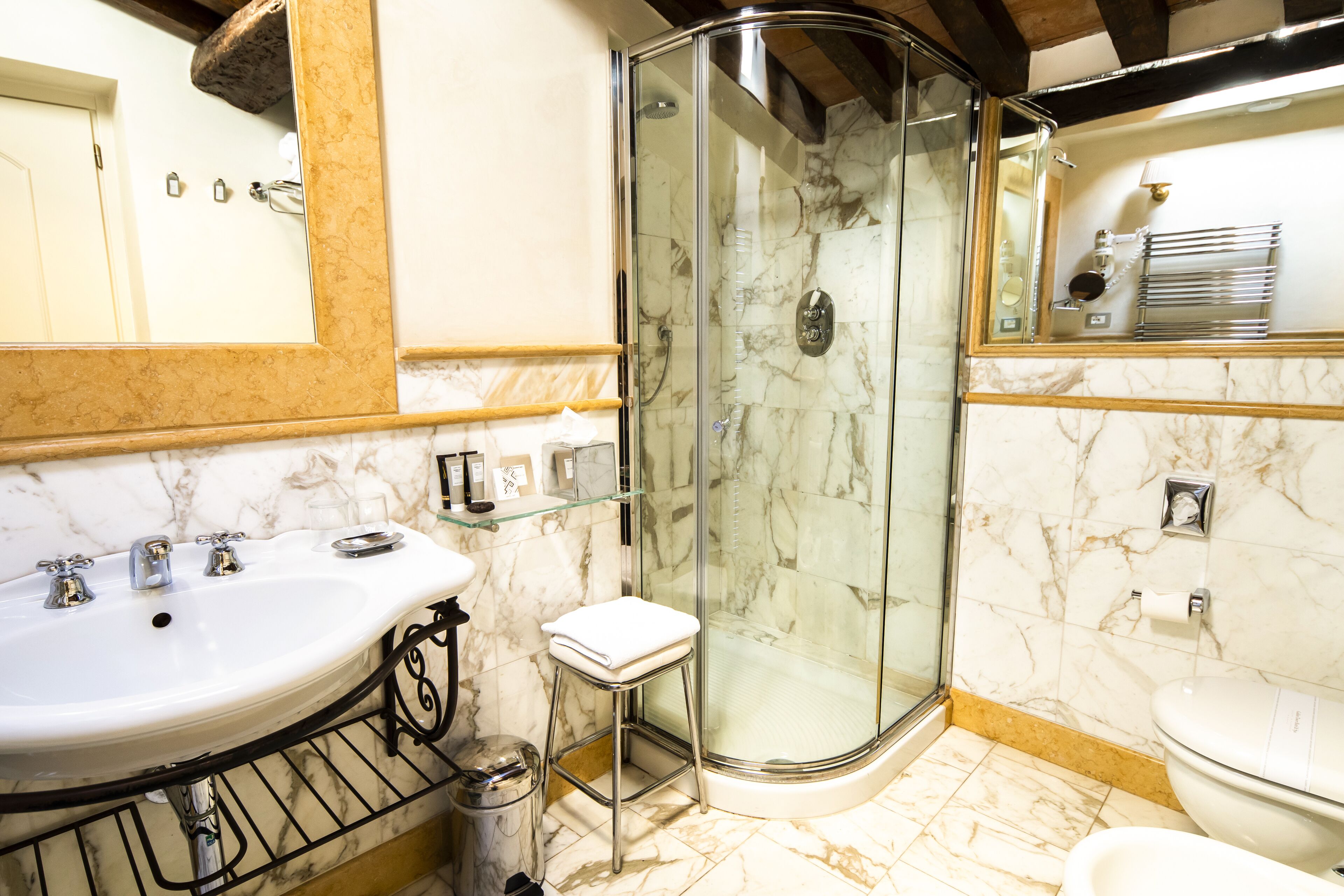 A bathroom with a glass-enclosed shower, a sink, and a toilet.