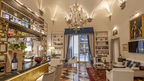 A spacious living area with a bar, bookshelves, and a chandelier.