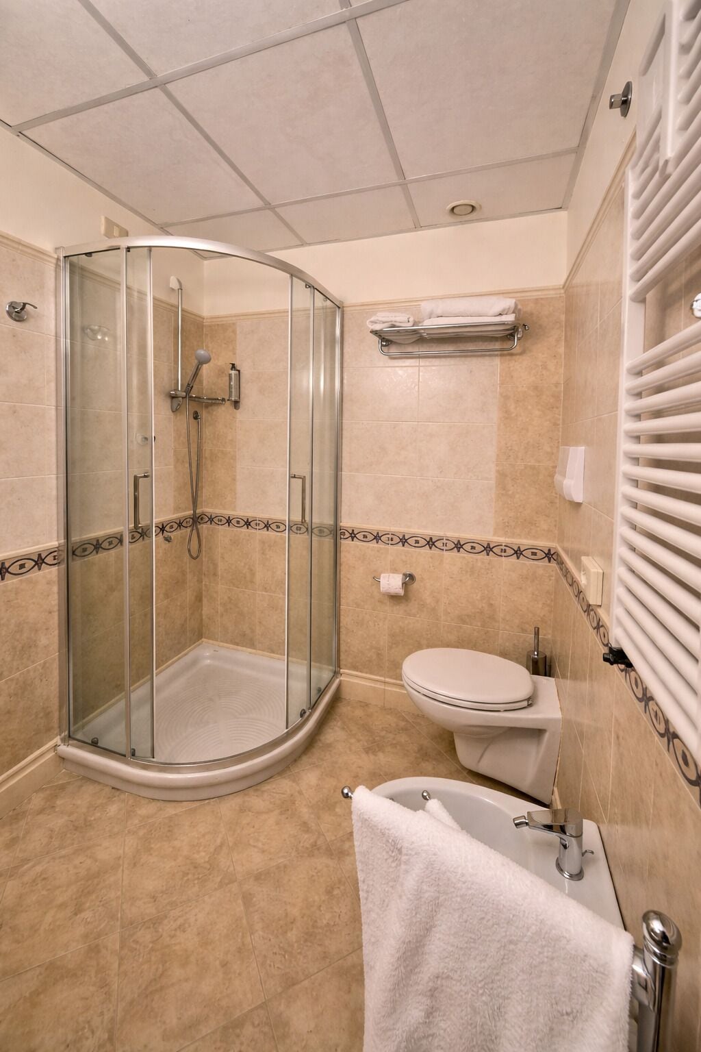 Un baño con ducha envuelta en vidrio, inodoro y bañera.