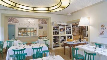 Un restaurante con varias mesas y sillas, una bodega y un candelabro.