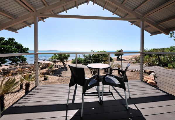 A covered outdoor seating area with a view of the beach and ocean. - Groote Eylandt Lodge (Alyangula)