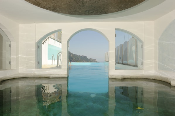 Una piscina al aire libre, sillones reclinables de piscina