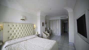 Una habitación de hotel con una cama grande, un escritorio y un televisor.