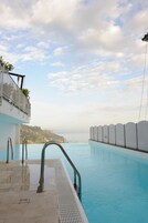 Una piscina al aire libre, sillones reclinables de piscina