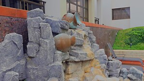Un muro de piedra con rocas grandes y una maceta rota.