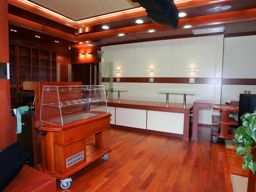 Un ristorante con un bancone in legno, una vetrina e una pianta.