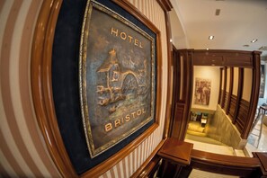 A framed sign with the words 'HOTEL BRISTOL' and a depiction of a building, likely indicating the hotel's name and location. - Bristol (Mostar)