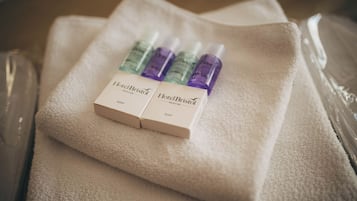 A white towel with two boxes of Hotel Bristol soap and three bottles of shower gel.
