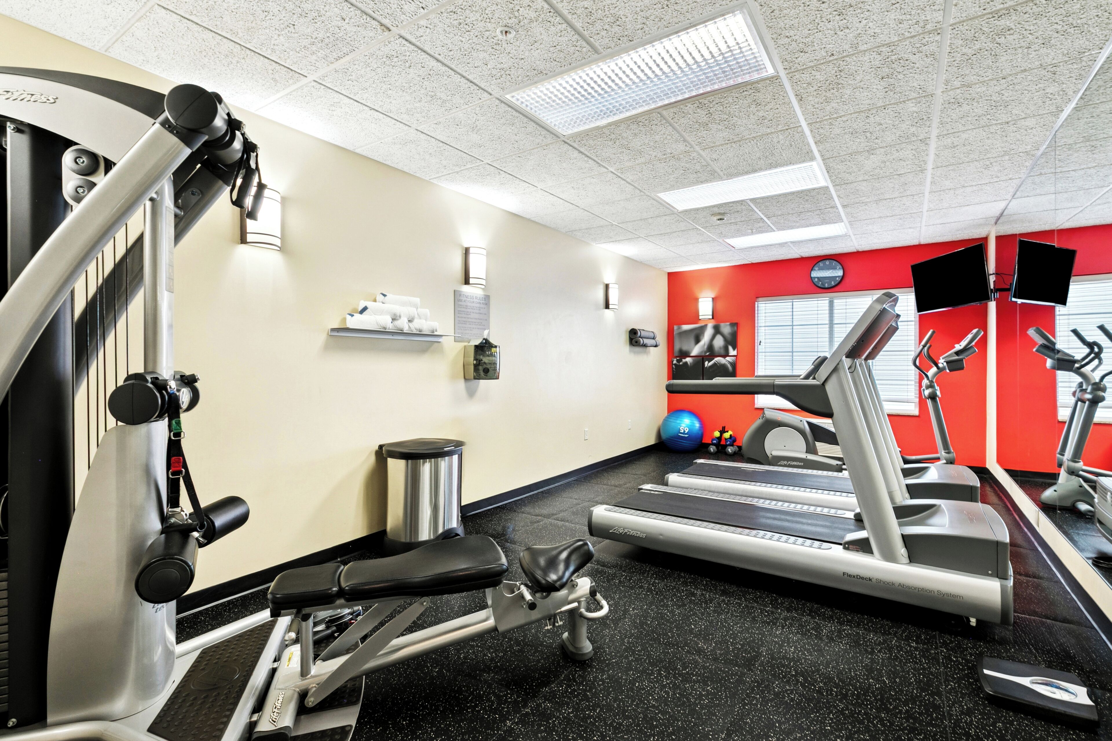 A gym with treadmills, weight machines, and exercise balls.